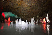 In einer Höhle werden Stalagmiten aus Eis vom Licht angestrahlt; Island