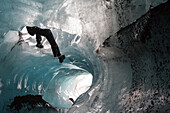 A climber descends by rope into a moulin on Skaftafell Glacier.; Skaftafell National Park, Iceland