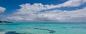 Türkisfarbenes Wasser des Karibischen Meeres mit Segelbooten am Horizont und Kumuluswolken am blauen Himmel vor dem Strand von Sainte-Anne auf Grande-Terre; Guadeloupe, Französisch-Westindien