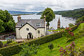 Ein Haus und eine Kirche stehen über dem Hafen in Tobermory, Isle of Mull, Schottland; Tobermory, Isle of Mull, Schottland