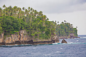 Cliffs along the rocky shoreline of Tuam Island one of the Siassi Islands in the Bismarck Sea off the north coast of Papua New Guinea; Siassi, Vitiaz Strait, Papua New Guinea