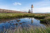 Der Rubha nan Gall (Stevenson) Leuchtturm in Tobermory, Schottland, spiegelt sich in einem Gezeitentümpel; Tobermory, Isle of Mull, Schottland