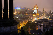 Der Turm des Balmoral Hotels, das Edinburgh Castle und die Innenstadt von Edinburgh, Schottland sind in der Abenddämmerung vom Calton Hill aus gesehen beleuchtet; Edinburgh, Schottland
