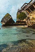 Eine hölzerne Aussichtsplattform und Menschen im Wasser mit Suluban Beach darunter; Uluwatu, Bali, Indonesien