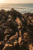 Nahaufnahme eines zerklüfteten Felsens entlang der Küste von Portugal bei Sonnenuntergang; Praia do Guincho, Cascais, Portugal