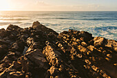 Nahaufnahme von Felsen am Ufer des Praia do Guincho bei Sonnenuntergang; Cascais, Portugal