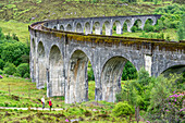 Zwei Wanderer gehen in Richtung des Viadukts bei Glenfinnan, Schottland; Glenfinnan, Inverness-shire, Schottland