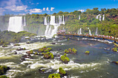 Touristen betrachten die Wasserfälle von einer erhöhten Plattform an den berühmten Iguazu-Fällen, Iguazu Falls National Park; Parana, Brasilien