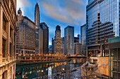 Cityscape of iconic office towers along the Chicago River, with view of the London Guarantee Building, Mather Tower, 35 East Whacker Building and the Kemper Building in the City of Chicago at dusk; Chicago, Cook County, Illinois, United States of  America
