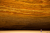 Eine Person im Schatten der gewaltigen Redwall Cavern am Colorado River.