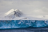 Landschaft mit einem tafelförmigen Eisberg auf dem Meer.