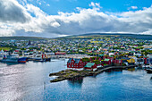 Überblick über den Hafen von Torshavn, der Hauptstadt des autonomen dänischen Territoriums der Färöer auf der Insel Streymoy, mit seinen historischen Parlamentsgebäuden auf dem Felsvorsprung im alten Stadtzentrum von Tinganes; Färöer Inseln