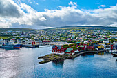 Overview of the harbor of Torshavn, the capital city of the autonomous Denmark Territory of the Faroe Islands on Streymoy Island, with its historical parliament buildings on the rocky outcrop in the old city center of Tinganes; Faroe Islands