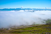 Fog covers the view of the mountain pass road to the summit of Hellisheiði Eystri; Ketilsstadhir, Austurland, Northern Region, Iceland
