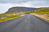 Paved road in the fjord landscape of Vestfjardarvegur trail in summer; Vestfjardarvegur, Westfjords, Iceland