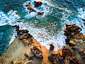 An aerial view of waves crashing against the Baja coastline.