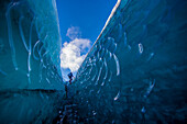 Eine Frau geht durch eine Gletscherspalte im Vatnajokull-Gletscher.
