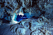 A cave diver passes through a beautiful white section of limestone deep inside of a cave system.