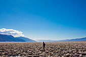 Ein Mann geht über die rissigen Wüstenebenen im Death Valley.