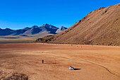 Eine Frau geht zurück zu ihrem Zelt in einem trockenen Seebett in 15.000 Fuß Höhe in der Atacama-Wüste.