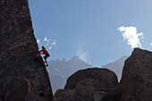 A climber on the 'Sharks Fin' formation; Mt. Whitney in the background.