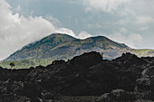 Vulkangestein und Blick auf den Mount Batur (Vulkan Kintamani) in South Batur bei bewölktem Himmel; Kintamani, Bangli Regency, Bali, Indonesien