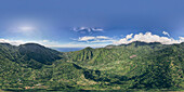 Panoramic overview of Mount Abang and surrounding mountains, with a blue sky, lush vegetation and an ocean view; Abang, Kabupaten Karangasem, Bangli Regency, Bali, Indonesia