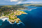 Aerial view of Devil's Tear and the rocky coastline of Nusa Lembongan with the turquoise waters of the Bali Sea crashing against the shore; Nusa Islands, Klungkung Regency, East Bali, Bali, Indonesia