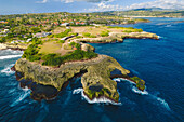 Close-up, aerial view of Devil's Tear and the rocky coastline of Nusa Lembongan with the turquoise waters of the Bali Sea crashing against the shore; Nusa Islands, Klungkung Regency, East Bali, Bali, Indonesia