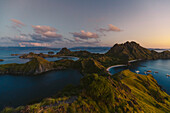 Boats moored in the bay at Padar Island in Komodo National Park in the Komodo Archipelago at sunset; East Nusa Tenggara, Indonesia