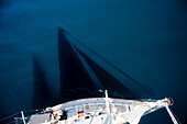 Der Schatten eines Segelbootes, der über den Ozean geworfen wird.