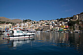 Kabinenkreuzer und Segelboote vor Anker im Hafen von Gialos, Insel Symi (Simi); Dodekanes-Inselgruppe, Griechenland