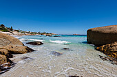 Large boulders frame the view of beachfront homes along the rocky shore at Clifton Beach on the Atlantic Ocean; Cape Town, Western Cape, South Africa