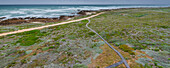 Boardwalk along the rocky shore and moorland at Cape Agulhas, the Southern Most Point of the Continent of Africa and the maritime border of the Indian and Atlantic Oceans in Agulhas National Park; Western Cape, South Africa