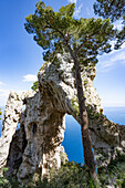 Blick durch den Arco Naturale, ein Kalksteinbogen aus der Altsteinzeit, Überreste einer eingestürzten Grotte, 18m hoch, Spannweite von 12m, an der Ostküste der Insel Capri; Neapel, Capri, Italien