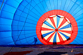 Partially inflated backlit hot air balloon with silhouette.; Ridgely, Maryland.