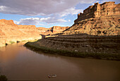 A whitewater raft floats through a flat section of the Colorado River.; Colorado River in Cataract Canyon, Utah.