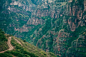 Spuren schlängeln sich einen Hang hinunter, felsige Ausläufer auf dem gegenüberliegenden Berg; Copper Canyon, Mexiko.