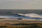 Wind, waves and fisherman in an SUV on a beach in the Outer Banks.; Outer Banks, North Carolina.