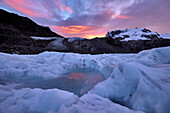 Gefrorene Wasserlache auf dem Eis des Gornergletschers bei Sonnenaufgang; Gornergrat, Zermatt, Schweiz.