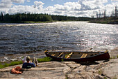 Kanufahrer schaut auf die Karte am Ufer; Winisk River, Nord-Ontario, Kanada.