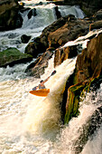 Ein Kajakfahrer, der sich über einen großen Wasserfall schwingt; Great Falls, Potomac River, Maryland.