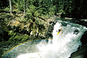 Woman running a big waterfall on the White Salmon River; Upper White Salmon River,Washington State, United States of America