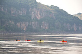 Kayakers paddle across flat water in The String of Pearls canyon.; Lower Congo River, Democratic Republic of the Congo.