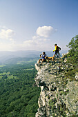 Cyclists relax on a rock outcropping overlooking Germany Valley.; Germany Valley, West Virginia.