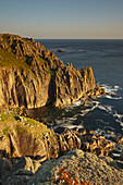 Warm sunlight on the cliffs at Gwennap Head overlooking the Atlantic Ocean near Land's End; Cornwall, England, Great Britain