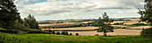 Blick auf grüne Ackerflächen und Weizenfelder in der Landschaft um Rockbourne, nahe Salisbury, unter bewölktem Himmel; Wiltshire, England