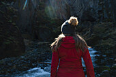 Blick von hinten auf eine Frau, die die Schluchten und die Landschaft von Thorsmork erkundet, einem Gebiet von außergewöhnlicher Schönheit in Südisland; Thorsmork, Südküste, Island