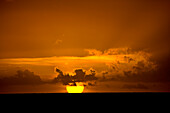 Brilliant golden sun setting over the Caribbean Sea, Tobago; Pigeon Point, Tobago, Republic of Trinidad and Tobago