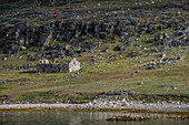 Tour group exploring the archaeological site of Hvalsey, near Qaqortoq,  where there is an ancient ruin of a church dating to 1300 AD at the Southern tip of Greenland; Southern Greenland, Greenland